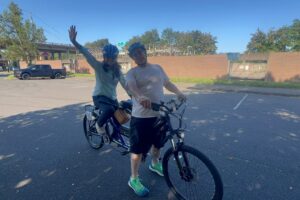 Picture showing the stoker fully seated with feet on pedals while the Captain is straddling the bike with the brakes on. This shows how you should be mounted on a Tandem to start.